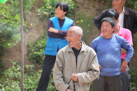朱家坪村村民听到现场募捐款基本上解决12家残贫户新房建设资金缺口问题，露出开心的笑容